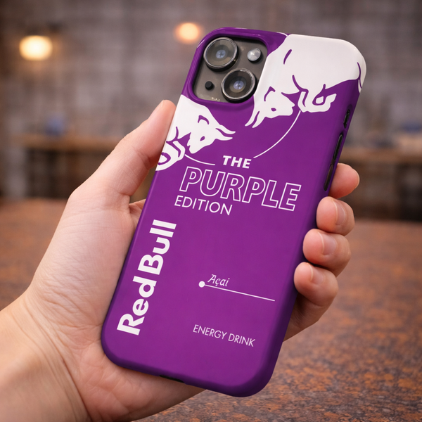Purple Red Bull phone case held in a hand with a blurred indoor background